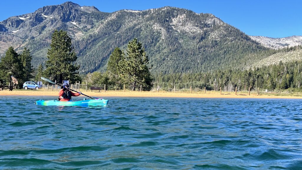 Photo of a kayak camper launching from Baldwin Beach in Lake Tahoe and heading towards Emerald Bay